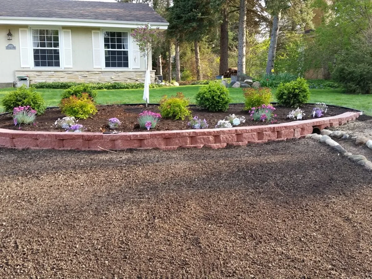 Curved block garden wall filled with flowering plants